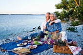 An old couple having a picnic on the beach
