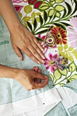 Woman pinning pattern to fabric