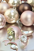 Pink Christmas baubles and one broken on