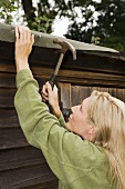 A woman fixing her shed