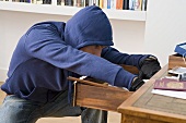 A burglar searching through a drawer