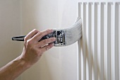 A man painting a radiator