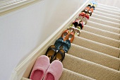 Ordentlich aufgestellte Schuhpaare auf Treppenabgang