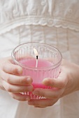 Girl holding burning scented candle