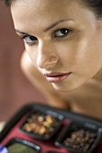 Woman holding a tray of spices (for spice body treatment)