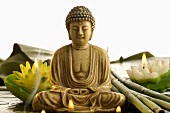 Buddhastatue mit Rauch und Seerosenkerzen