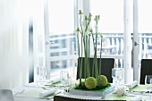 Laid dining table with flower arrangement, light balcony behind