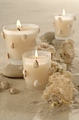 Windlights decorated with shells in sand