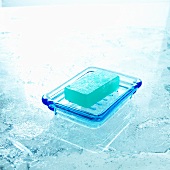 Bar of pale blue soap in a soap dish