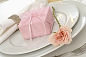 Place-setting with gift in pink wrapping paper