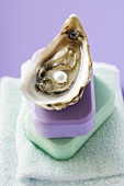 Oyster with pearl and two bars of soap on towel