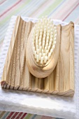 Wooden soap dish with brush on white towel