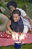Paar mit Wunderkerzen beim Picknick am 4th of July (USA)