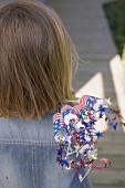 Small girl holding 4th of July decorations (USA)