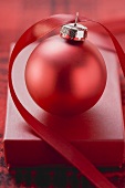 Red box and Christmas bauble with ribbon
