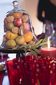 Früchte und Nüsse unter Glashaube (weihnachtlich)