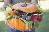 Man holding pumpkin decorated with flowers