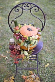 Pumpkin decorated with flowers on garden chair