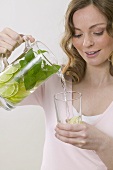 Woman pouring lemonade into glass