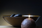 Healing stones in wooden bowl, candle