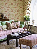 Romantisches Wohnzimmer mit pastellgrünem Sofa und einem Mix an floralen Mustern