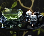 Glass bowl and tealights on side table