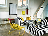Helles, modernes Wohnzimmer in traditionellem schwedischen Haus mit steilem Treppeaufgang, rustikalem Holzdielenboden und schwarz-weiss gestreiften Liegemöbeln