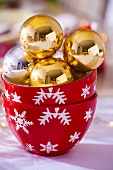 Gold Christmas baubles in two bowls