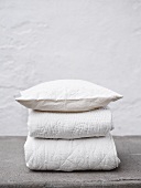 Folded bedspreads and a pillow