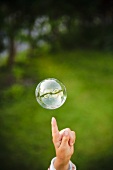Finger pointing to a soap bubble