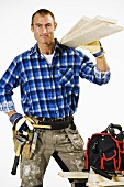 A handyman with wooden boards and tools