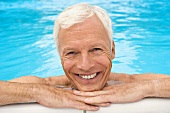 Germany, senior man relaxing in pool, close-up, portrait