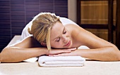 Germany, young woman lying on massage table