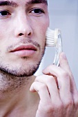 Man massaging face with brush