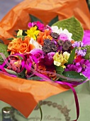 Bouquet of summer flowers in orange paper
