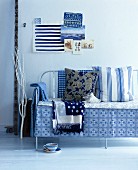 Blue and white cushions and blankers on a metal bench cushions and blankets