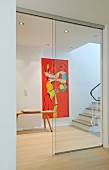 Hallway with staircase, artwork on wall and sliding glass door