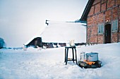 Outdoor cooking fire in front of snow-covered half-timbered house