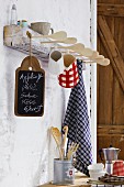 Hand-crafted rack with tea towels, cups & jugs hanging from wooden spoons