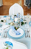 A table laid for Christmas dinner decorated in sliver, blue and white