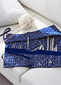 Knitting and crochet needles in blue and white fabric needle case