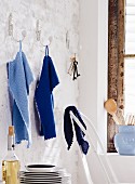 Blue, knitted towels hanging on wall hooks