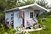 Blaues Gartenhaus aus Holz im skandinavischen Stil als Künstleratelier