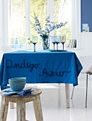 A table with an azure blue, embroidered table cloth