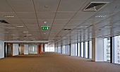 Ceiling panels with technical installations in spacious hall with floor-to-ceiling windows