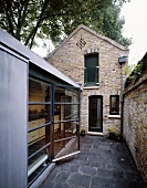 Old home with brick facade and modern extension with glass in a courtyard