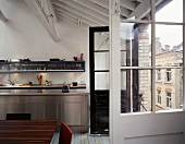 Offene Balkontüren im ausgebauten Loft mit Edelstahlküche
