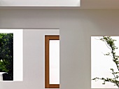 Zeitgenössische Architektur mit Ausschnitten in Wand und Blick in Innenhof