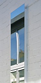 Tall, narrow window in a whitewashed brick facade