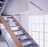 Simple stairway with metal steps in front of an atelier window